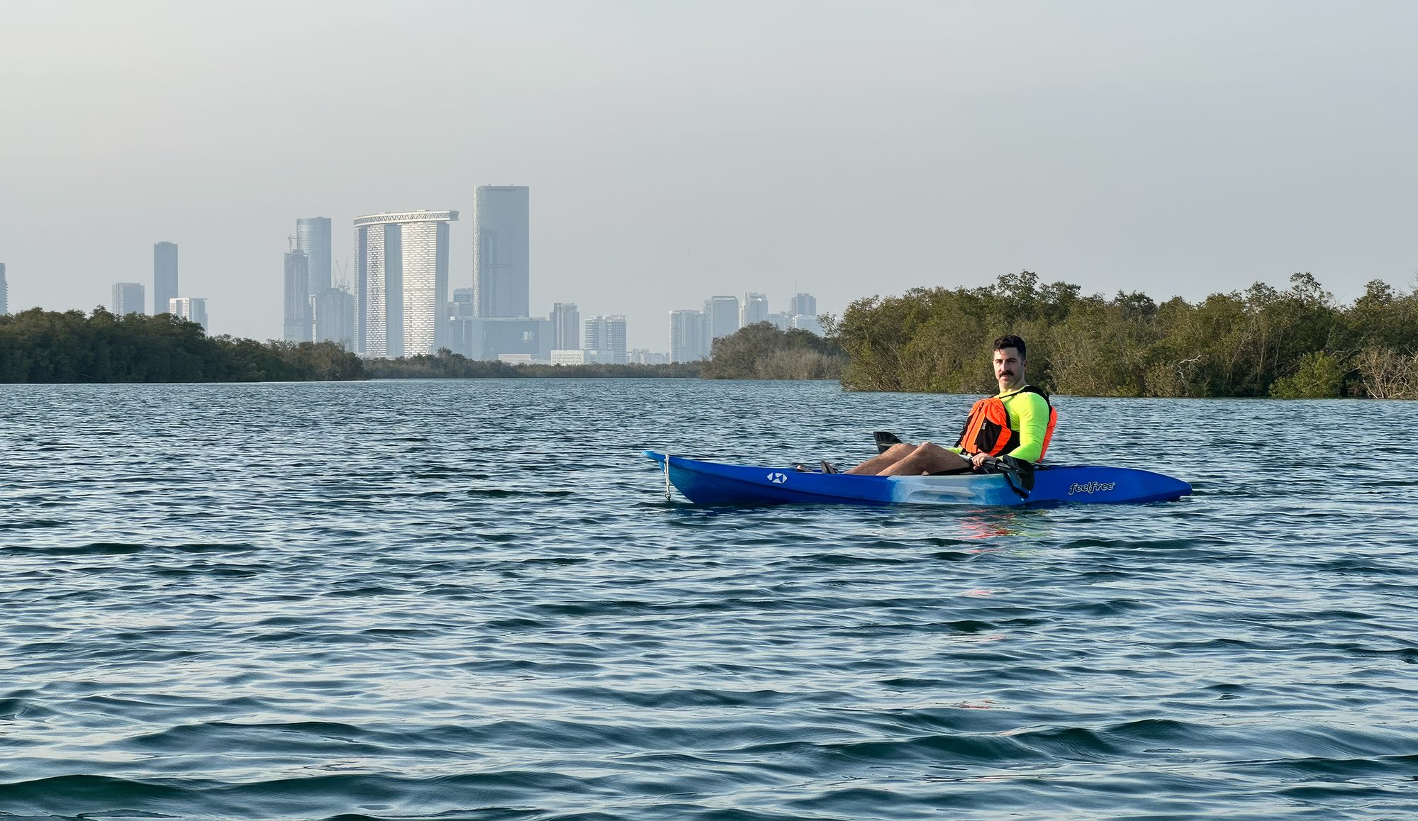 Guilherme Abuchahla kayaking with the Abu Dhabi skyline behind
